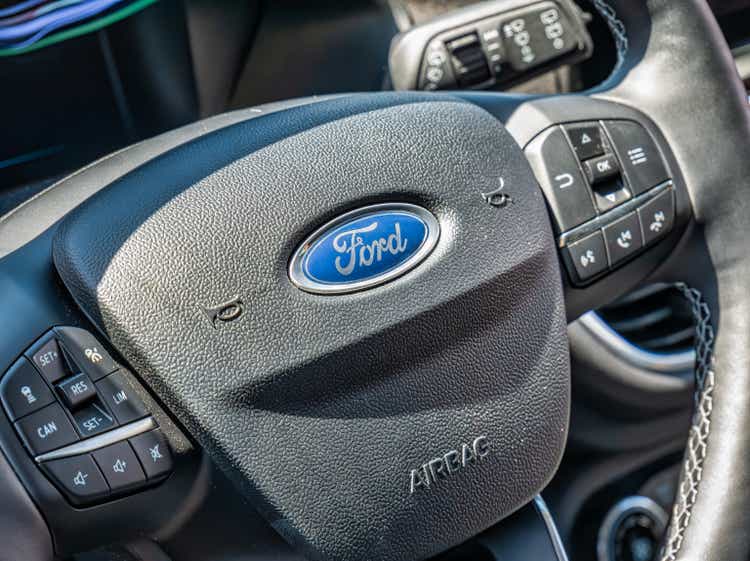 Close up detail with the logo of Ford company car on a steering wheel