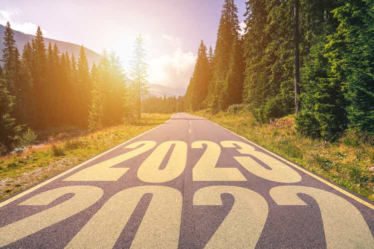 Empty asphalt road and New year 2023 concept. Driving on an empty road in the mountains to upcoming 2023 and leaving behind old 2022. Concept for success and passing time.