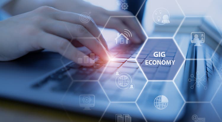 Gig economy, freelance, hybrid workplace concept. The combination of employment trend; growing to external hiring. Independent workers engage in short term work arrangements. Working with computer.