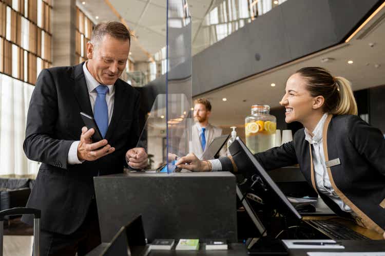 Female receptionist and a male guest talking on the reception desk