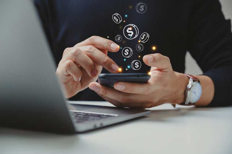 Hand of businessman using smart phone with coin icon.