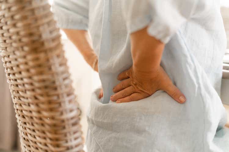 Senior woman massaging the pain in her lower back