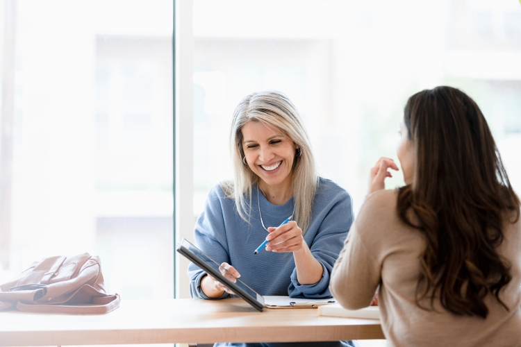 Female financial advisor reviews documents on digital tablet