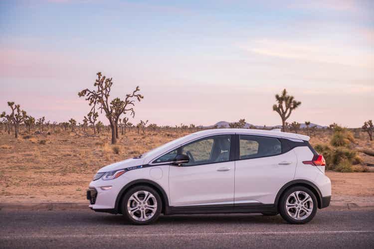 Chevy Bolt electric vehicle parked on scenic road in Joshua Tree National Park, USA at dusk