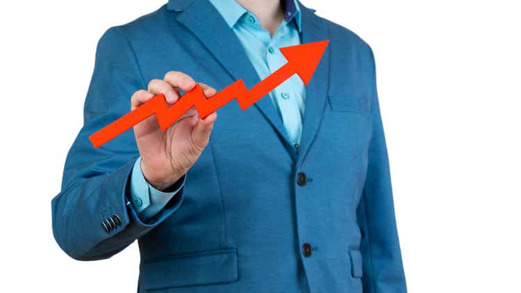 businessman holds a red arrow chart pointing up