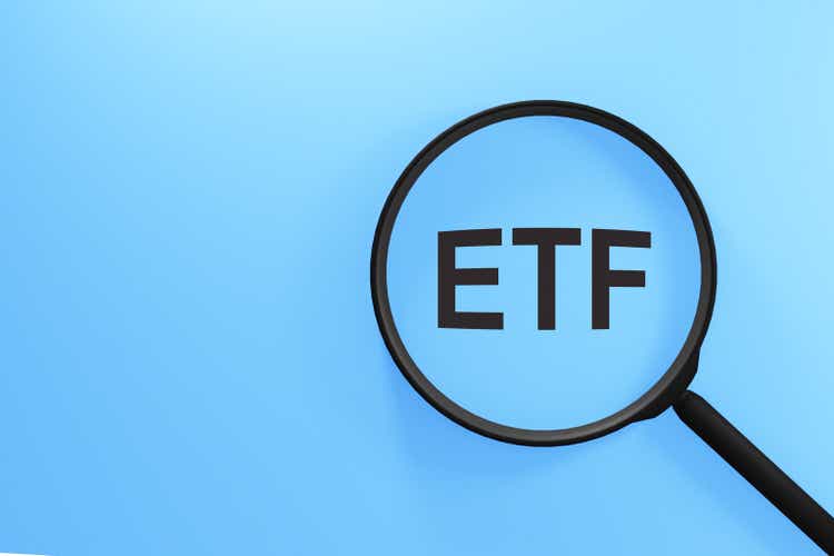 ETF acronym through magnifier. Investing and assets concept.