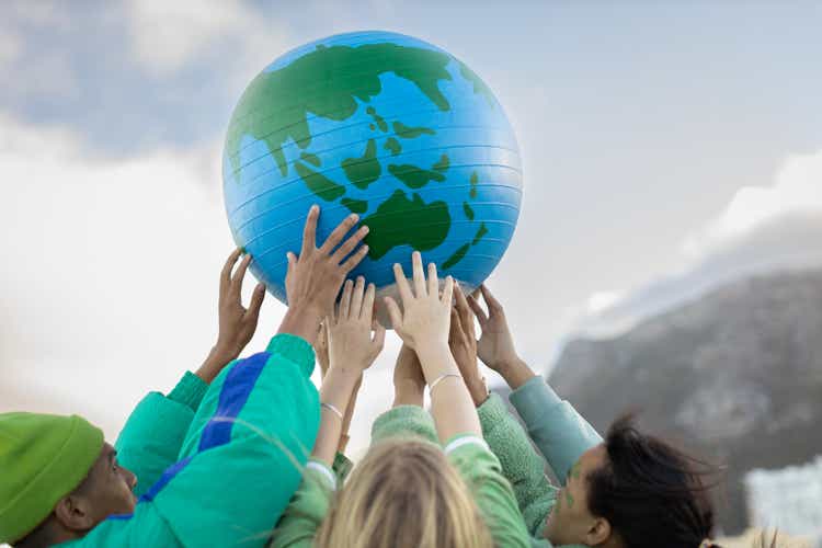 Group of teenagers holding up the world