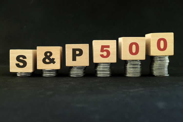 United States US stock market economy growth and recovery concept. S&P500 index in wooden blocks with increasing stack of coins in black background.