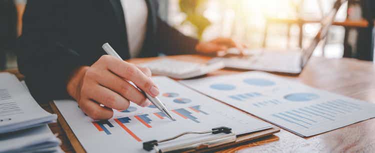 Portrait of a woman working on a tablet computer in a modern office. Make an account analysis report. real estate investment information financial and tax system concepts