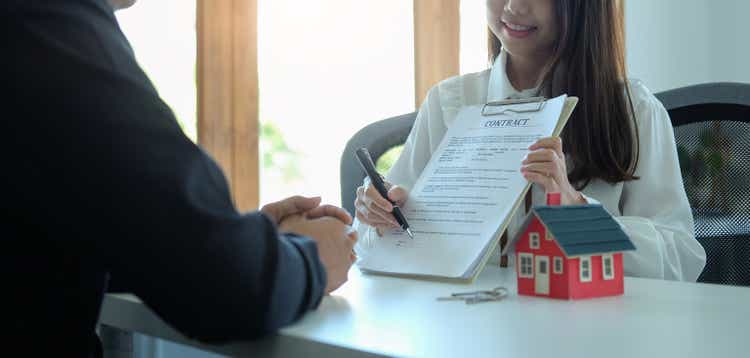 Young asian man negotiate with real estate agents about renting or buying home in the office."t