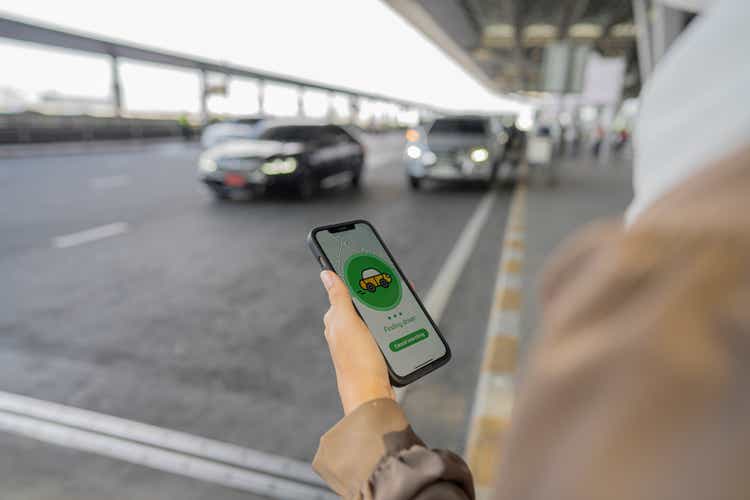 Muslim business waiting for uber taxi at outside airport.