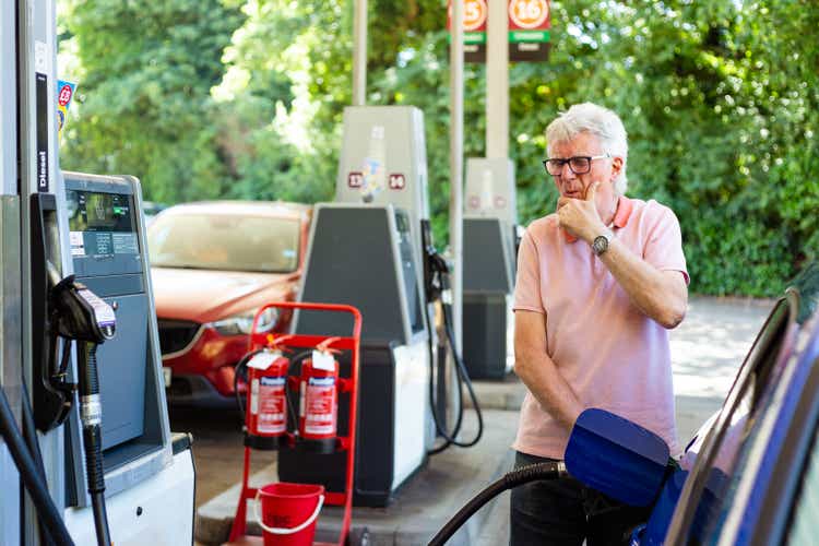 Shocked man filling car up at gas station