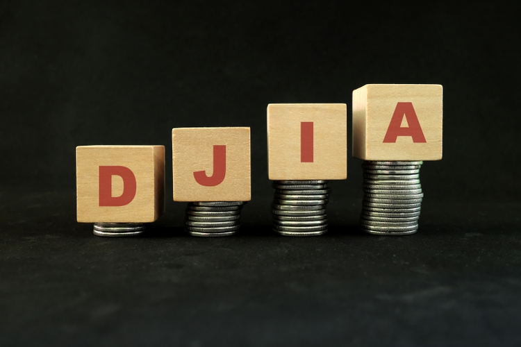 US stock market economy growth and recovery concept. Dow Jones Industrial Average or DJIA index in wooden blocks with increasing stack of coins in black background.