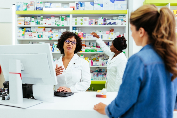 Pharmacist in friendly talk with regular customer