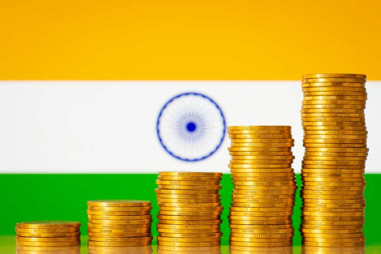 Stacks of golden coins forming uprising graph in front of India flag