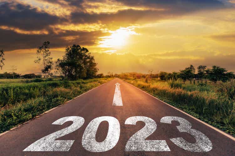 Empty asphalt road and new year 2023 concept. Driving on empty road to Goal 2023 when the sun goes down.