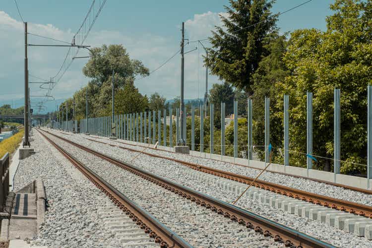 Nueva vía férrea moderna, recién construida, muro de barrera acústica está a punto de ser levantado y construido. Día soleado.