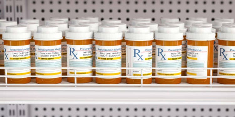 Row of drug bottles and pill tablet box on the farmacy shelf.