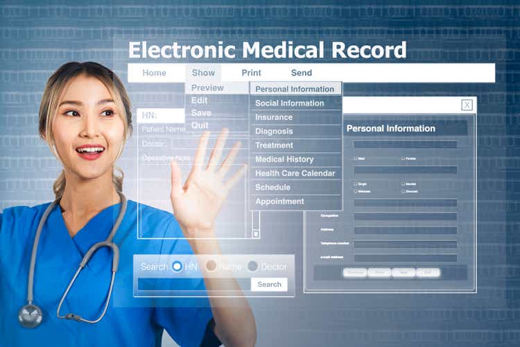 Female doctor with display screen showing electronic medical record.