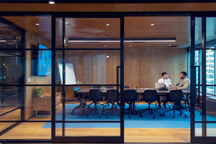 Business people working in a board room with a laptop and digital tablet