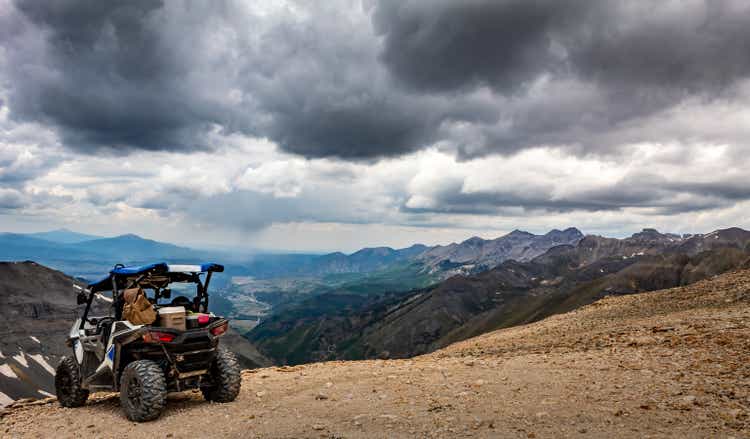 Side by side UTV ATV RZR with Mountain range in the background at the summit of Imogene pass near Silverton Telluride and Ouray Colorado in the San Juan Mountains, Rocky Mountains Colorado. Telluride, Colorado in the distance.