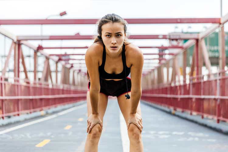 Young woman resting after running in city