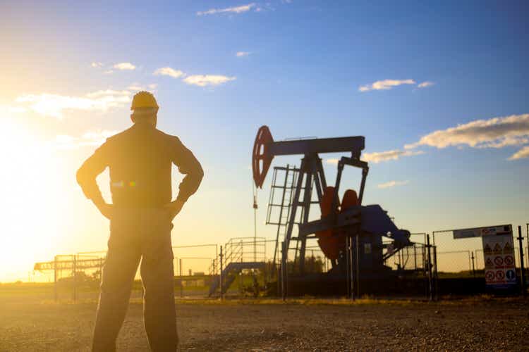 Oil worker in front of a pumpjack