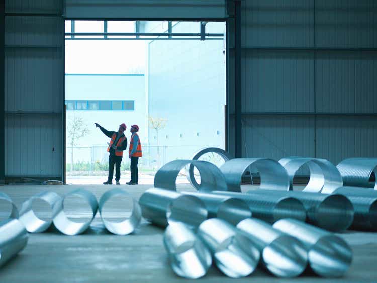 Foreman and apprentice in the door in the construction site factory