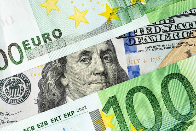 Franklin from a 100 US dollar banknote looks out between two 100 euro banknotes. The relationship between Europe and America, America