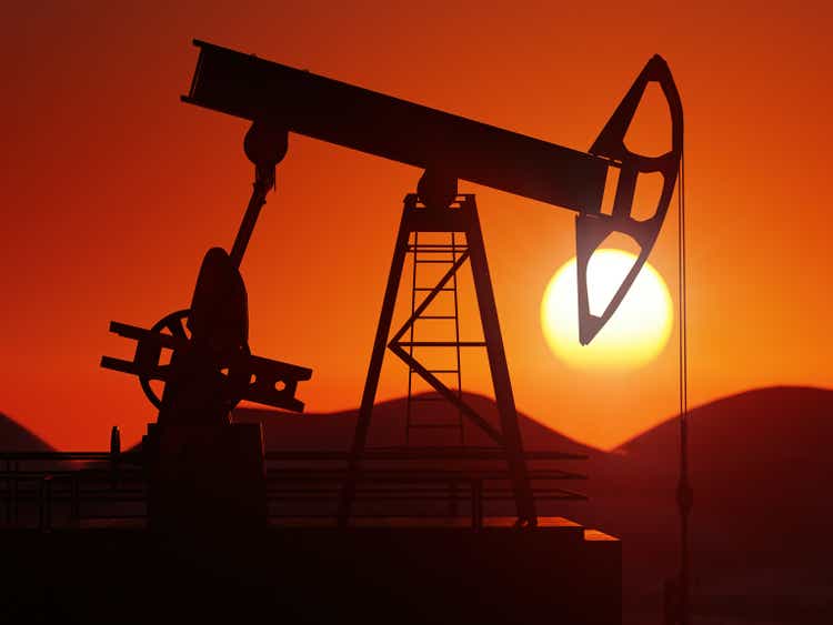 Oil pumping jack silhouette against the sunset