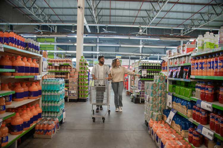 Couple pushing empty trolley in supermarket