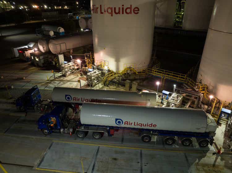 Air Liquide tanker trucks being filled at a gas facility.