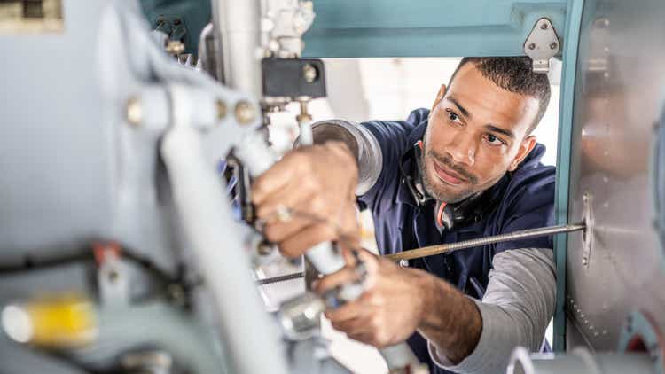 Aviation mechanic repairing jet, inside of engine view