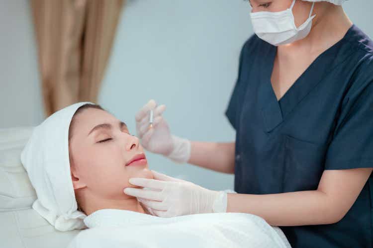 Caucasian women undergoing beauty spa botulinum neurotoxin Botox treatment for anti-aging, to smooth wrinkles as a cometic solution. Injecting forehead to relax muscles with a non-invasive procedure.