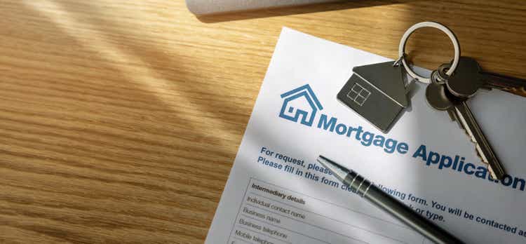 mortgage loan application form and new home keys on the bank office table. copy space