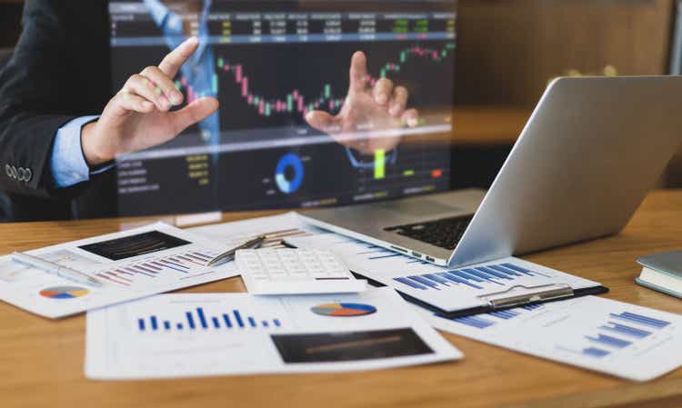 Businessman at office desk analyzing financial markets and planning investment business.