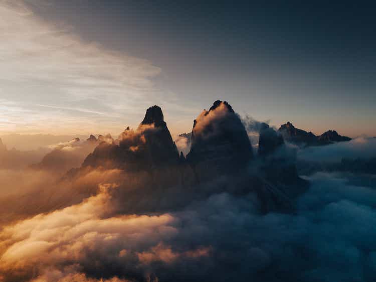 Tre Cime di Lavaredo surrounded by clouds on a summers evening seen from a drone, Dolomites, Italy