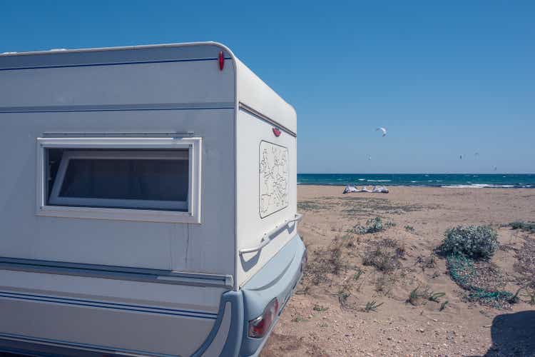 A white caravan with a map of the world drawn on the back