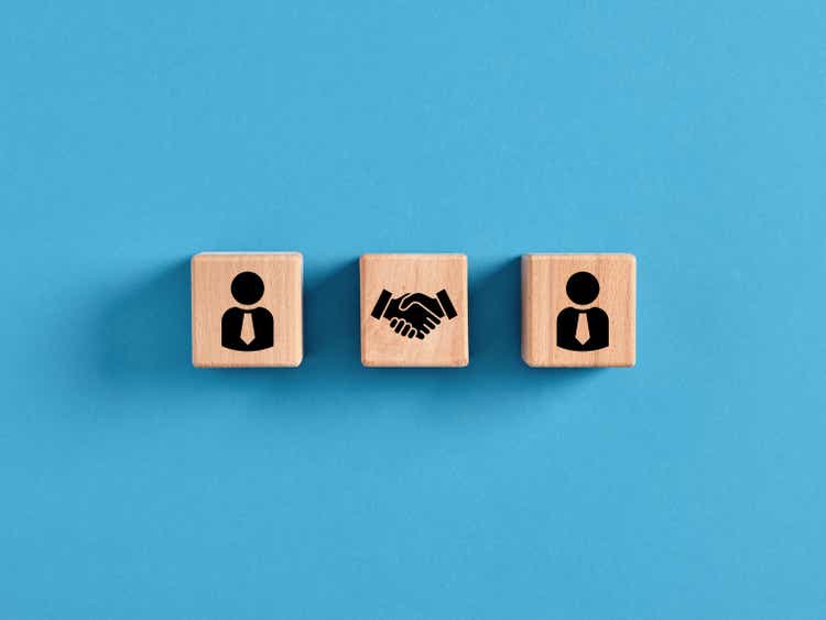 Business deal, agreement or contract concept. Employee manager and handshake icons on wooden cubes
