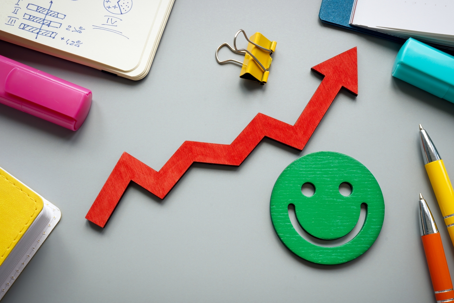 Customer satisfaction and feedback concept. Rising arrow and smiley on the desk.