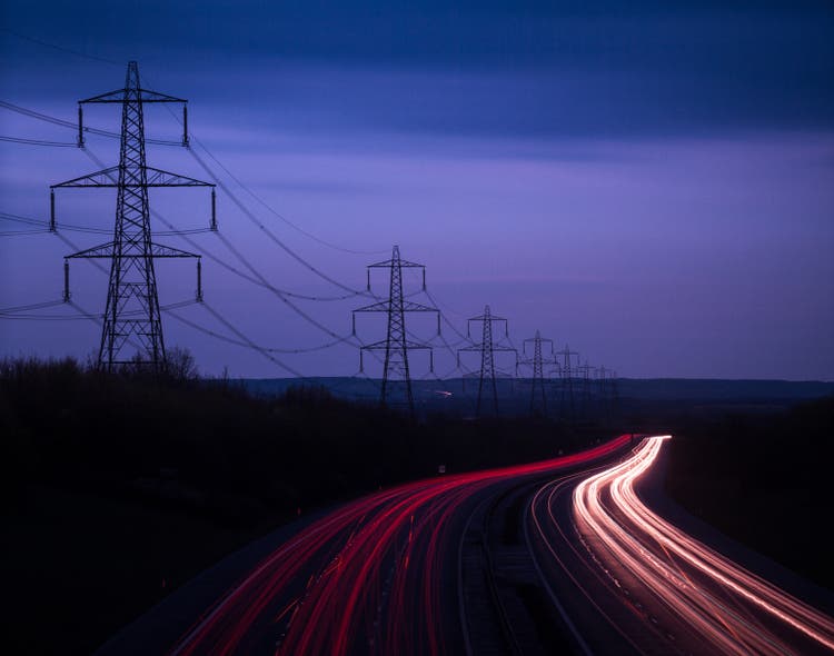 M40 Motorway light trails and power cables at dusk, Oxfordshire, England, United Kingdom, Europe