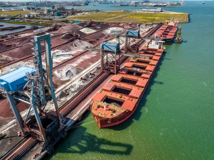 Kräne, die Fracht von einem Massengutfrachtschiff im Hafen entladen