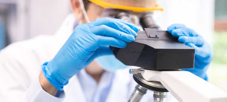 professional research scientist concentration using microscope in chemistry medicine laboratory, technician working with medical science technology equipment for biotechnology or biology experiment