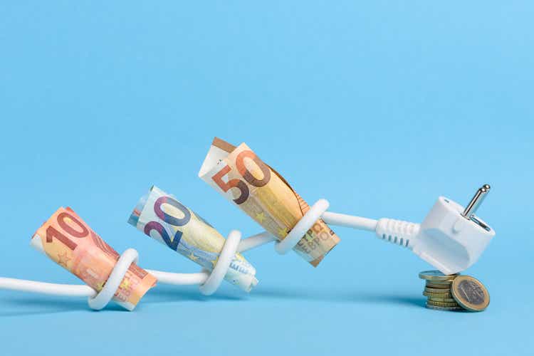 Euro bills tied in knots in power electrical power cable on blue background