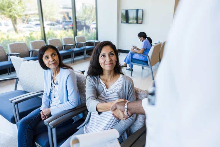 Mother watches as daughter shakes hands with ER doctor