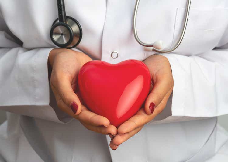 Medicine doctor holding red heart shape in hand, medical concept stock photo