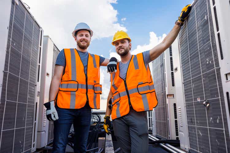 An engineer and a technician posing near the roof