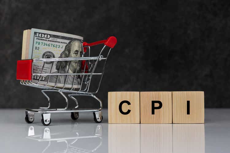 Roll of dollars in shopping cart and wooden blocks with the word cpi on dark grey background. Buy or Sell. Business and CPI, consumer price index concept.