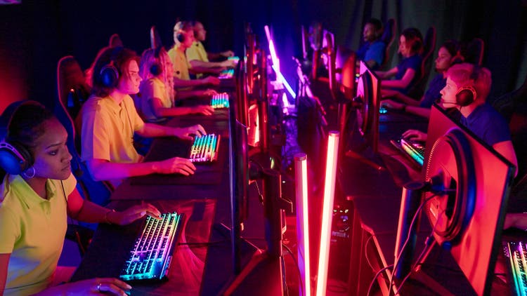 Diverse yellow pro gamer female team with african ethnicity leader competing in video game eSport championship. Blue team on the other side