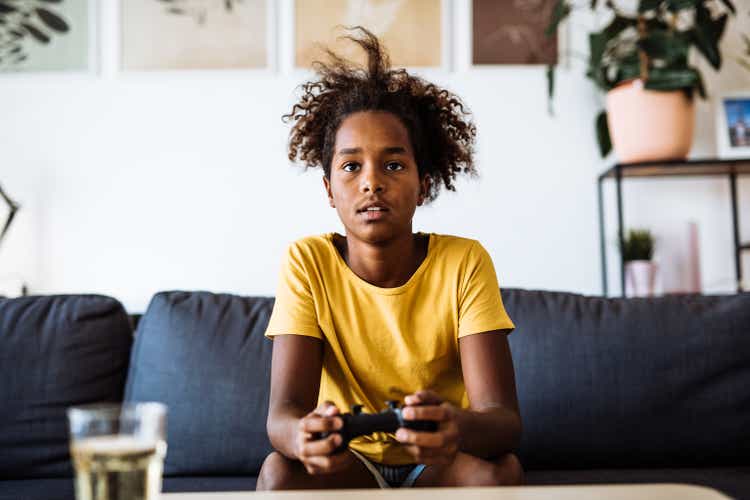 Eleven year old African-American school girl playing video games online